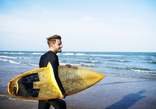 A man carrying a surfboard